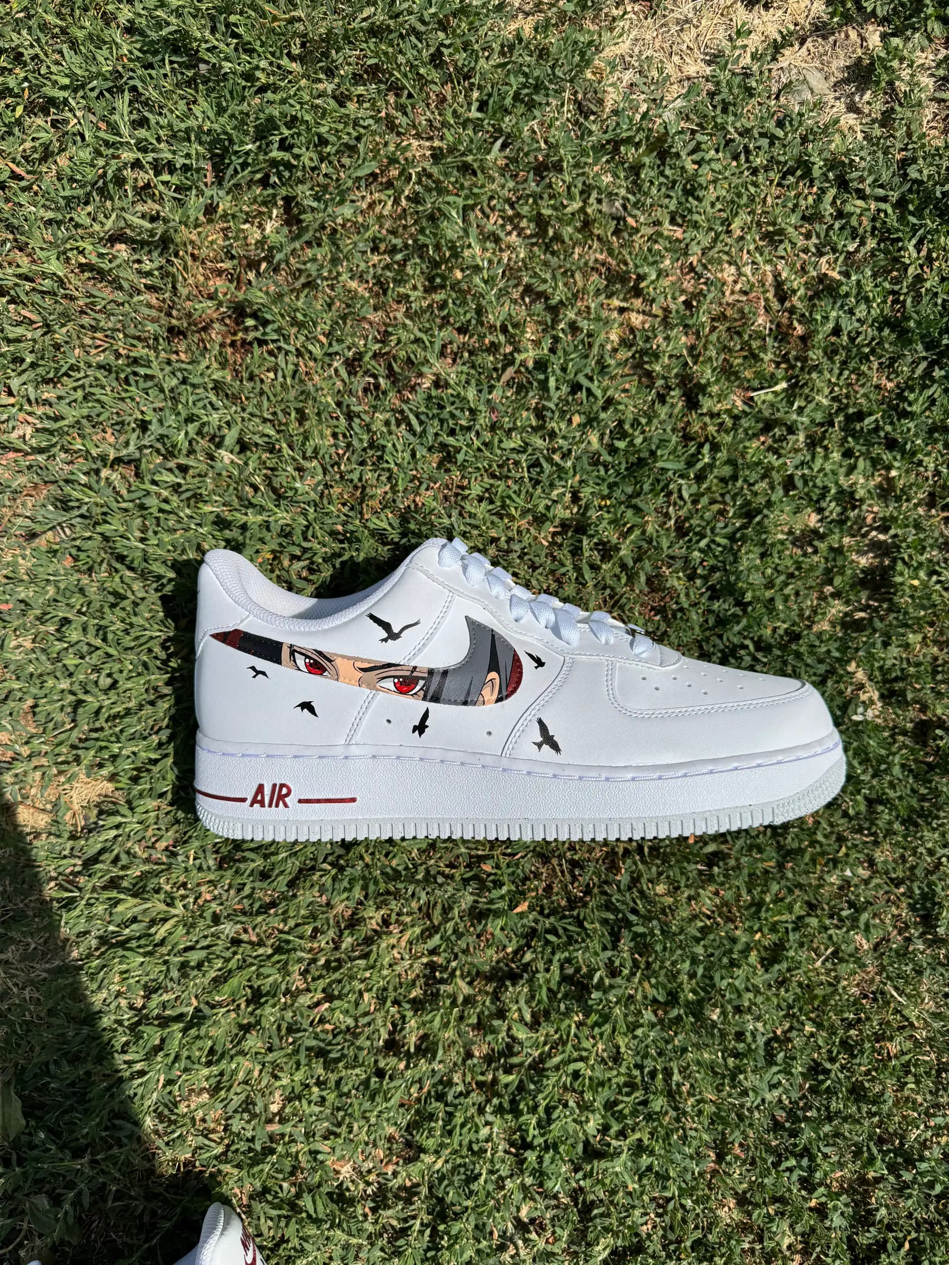 Air Force 1 con los ojos rojos de un personaje de anime en el swoosh y cuervos negros alrededor